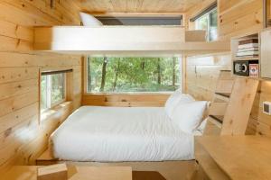 a bed in a tiny house with a window at Postcard Cabins Machimoodus, Outdoor Collection by Marriott Bonvoy in Moodus