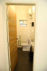 a bathroom with a toilet and a sink and a door at T Nagar 1BHK Studio Shopping Cntrl - G3 Tulsi in Chennai