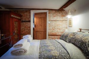 a bedroom with a bed and a brick wall at The Old Scullery in Bungay