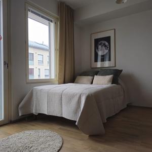 a bedroom with a bed and a window at Uusi tyylikäs asunto ydinkeskustassa in Lappeenranta +7 photos