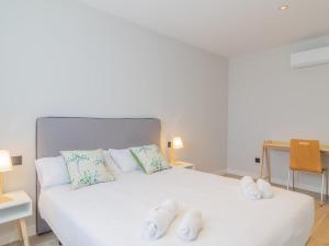 a bedroom with a white bed with white shoes on it at Apartamento Mar Salada Rosamunda in Santander