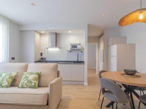 a living room and kitchen with a couch and a table at Apartamento Mar Salada Rosamunda in Santander