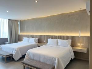 ein Hotelzimmer mit zwei Betten und einem Stuhl in der Unterkunft Hotel Alcalà Centro in Guadalajara + 23 Fotos