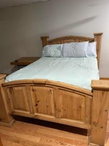 a wooden bed with white sheets and pillows on it at Peaceful Resort Retreat in Springfield