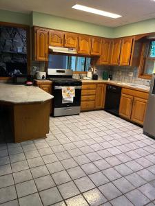 a kitchen with wooden cabinets and a tile floor at Peaceful Resort Retreat in Springfield