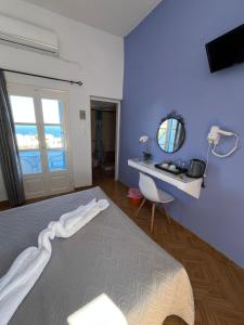 Un dormitorio con una cama grande y un espejo. en Stella Nomikou Apartments, en Firostefani