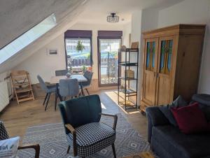 a living room with a couch and a table and chairs at Ferienwohnung am Maarberg in Ulmen in Ulmen