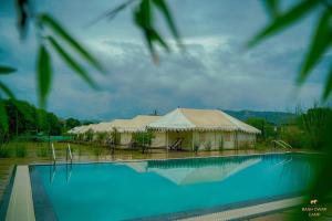 una gran carpa junto a una piscina en Baagh Dwar Camp & Resort, en Khilchīpur