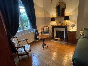 a living room with a table and a fireplace at Les glycines in Bonneval