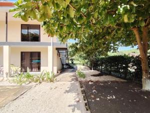 CuajiniquilにあるCasa Chika Playa Grande Guanacaste 1の前に木がある家