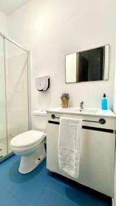 a white bathroom with a toilet and a sink at Oi Braga Hostel in Braga +33 photos