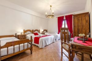 a bedroom with two beds and red curtains at Hotel Castello di Giuliano in Montelepre