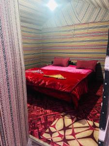 a bedroom with a red bed in a room at Sunrise Magic Camp in Wadi Rum