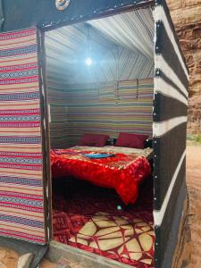 a small room with a bed in a tent at Sunrise Magic Camp in Wadi Rum