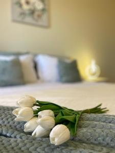 Ein Haufen weißer Blumen auf einem Bett in der Unterkunft Shkodra Central Corner in Shkodra