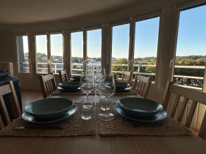 Un comedor con una mesa con platos y copas de vino. en Beaux-Regards, en Saint Lo 8 fotos más