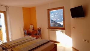 a room with a bed and a window with a mountain at Agriturismo Ferienhof Gschloier - Adults only in Laion