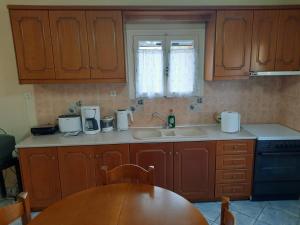 a kitchen with wooden cabinets and a wooden table at The olive House in Leonidio +13 photos