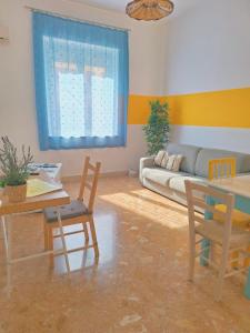 a living room with a couch and a table and chairs at Vento di Grecale - a pochi metri dal mare in Santa Flavia