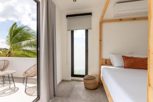 a bedroom with a bed and a balcony at Exclusieve villa LXRY Brakkeput in Willemstad +26 photos