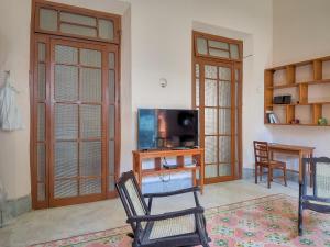 a living room with two chairs and a television at Casa Arabe - Yucatan Home Rentals in Mérida
