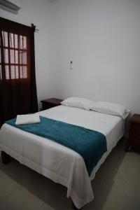 - une chambre avec un grand lit blanc et une couverture bleue dans l'établissement Villa Regina en Villas Camino Real cerca de las dunas de Chachalacas, à Ursulo Galván