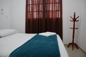 une chambre avec un lit avec une couverture bleue dans l'établissement Villa Regina en Villas Camino Real cerca de las dunas de Chachalacas, à Ursulo Galván