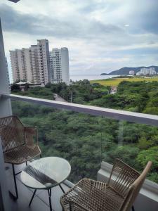 a balcony with two chairs and a table and a view at MySuyte in Santa Marta