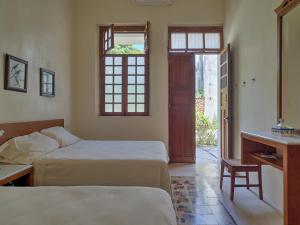 a bedroom with two beds and a window and a door at Casa Arabe - Yucatan Home Rentals in Mérida +39 photos