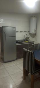 a kitchen with a stainless steel refrigerator and a table at Departamento nuevo cerca de micro centro 4 in San Luis