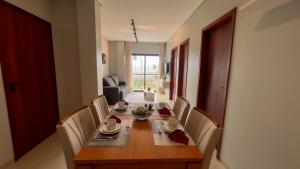 ein Esszimmer mit einem Holztisch und Stühlen in der Unterkunft Apto Vista Mar Área Gourmet Piscina 2 Suítes in São Bento
