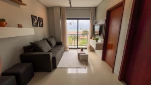 ein Wohnzimmer mit einer Couch und einem Fenster in der Unterkunft Apto Vista Mar Área Gourmet Piscina 2 Suítes in São Bento