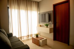 ein Wohnzimmer mit Couch und großem Fenster in der Unterkunft Apto Vista Mar Área Gourmet Piscina 2 Suítes in São Bento + 35 Fotos