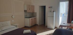 a small kitchen with a bed and a refrigerator at Le Suite del Lungomare in Taranto