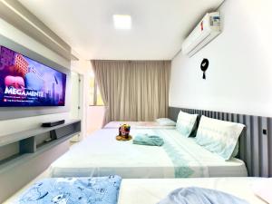 Una habitación de hotel con dos camas y un televisor. en Casa Completa com Churrasqueira Wi-Fi e Garagem para 2 Carros a 400m da PRAIA Acomoda 8 Pessoas, 3 suites com Ar-Condicionado, en Piçarras