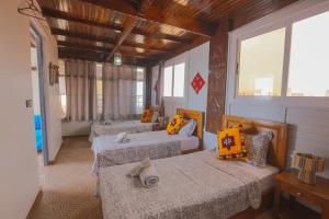 a room with three beds in a room with windows at Blue Rina Hostel in Agadir