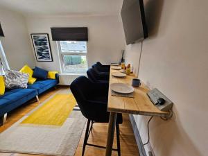 ein Wohnzimmer mit einem Tisch und einem blauen Sofa in der Unterkunft CityPad Cardiff in Cardiff + 14 Fotos