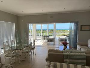 a living room with a couch and a glass table at Coastal Escape in Struisbaai in Struisbaai