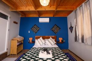 a bedroom with a blue wall and a bed at Blue Rina Hostel in Agadir