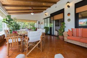 un soggiorno con tavolo, sedie e divano di Villa Soliva a Mondello