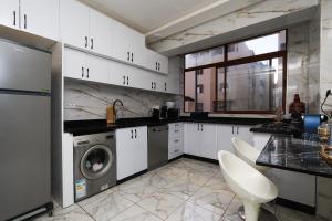 Una cocina con gabinetes blancos y lavadora. en New appartement in Salé, 10 min from Rabat, en Oulad Akkou 47 fotos más