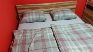1 cama doble con 2 almohadas y pared roja en Apartment Borovnica Rogla, en Resnik