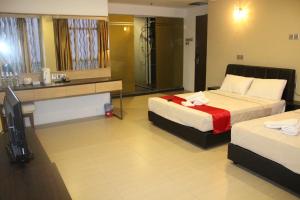 a hotel room with two beds and a shower at T Hotel Jalan Tar in Kuala Lumpur
