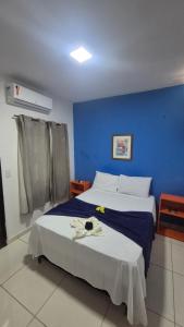 a bedroom with a bed with a blue wall at Magia D'ajuda Hospedagem - Centrinho, próximo à Mucugê in Arraial d'Ajuda +126 photos