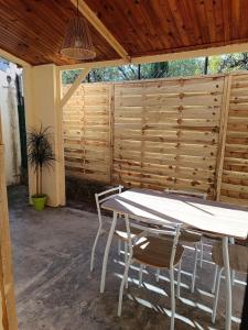 a table and chairs in a patio with a fence at La Villa des Trois in Cavaillon