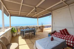 a room with a balcony with a table and chairs at Blue Rina Hostel in Agadir