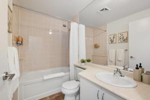a bathroom with a sink and a toilet and a bath tub at Modern Lakeside 1BR Condo in Downtown Toronto in Toronto
