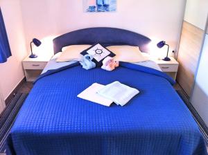a blue bed with two stuffed animals on it at Apartments Luna in Lovran