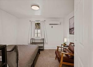 a bedroom with a bed and a chair and a window at Blue Ox in Pensacola