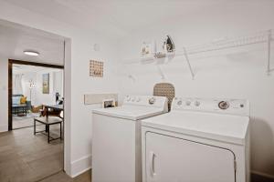a white laundry room with a washer and dryer at Blue Ox in Pensacola +16 photos